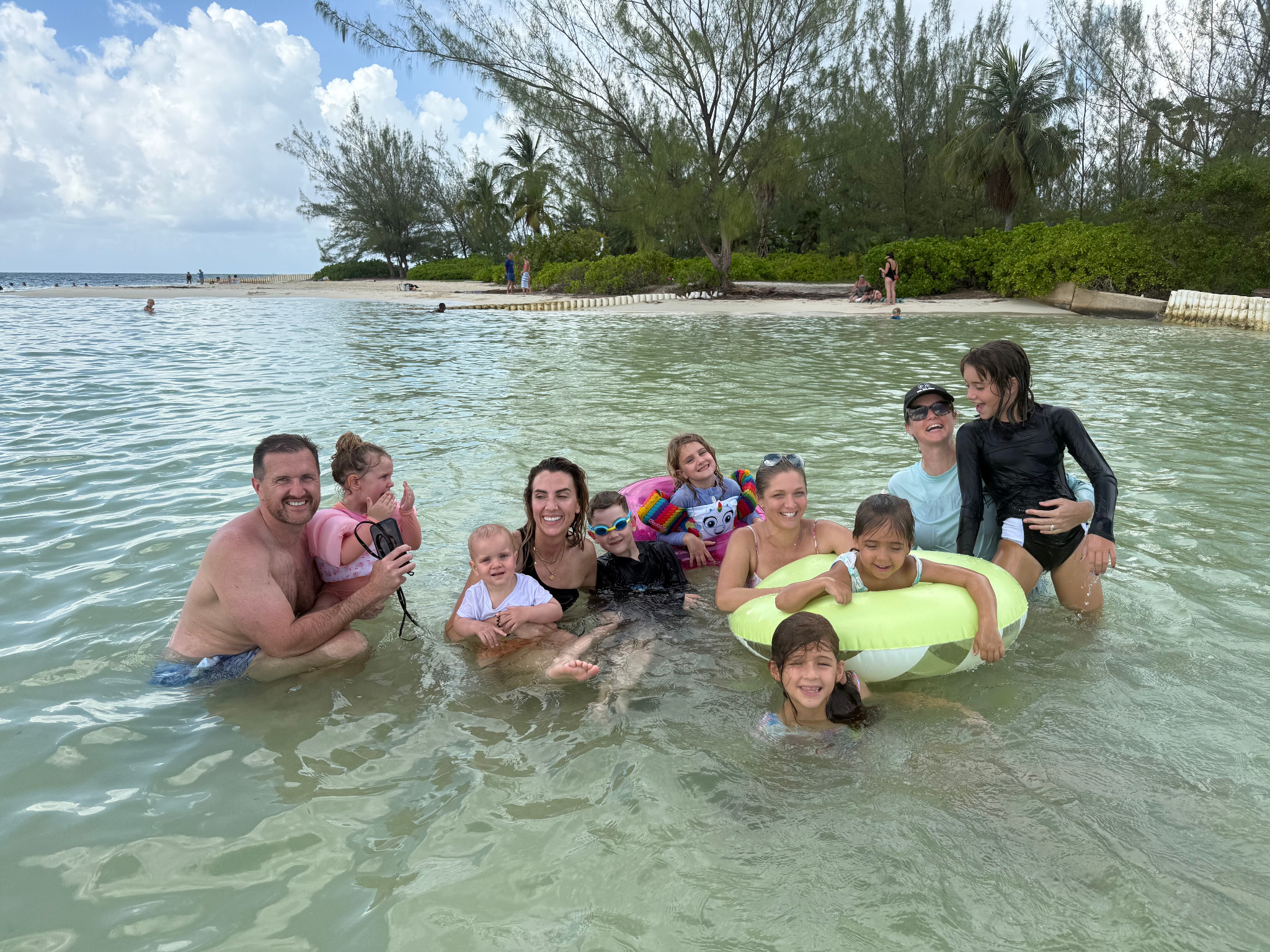 Families and children enjoying calm shallow water together during a Grand Cayman outing.